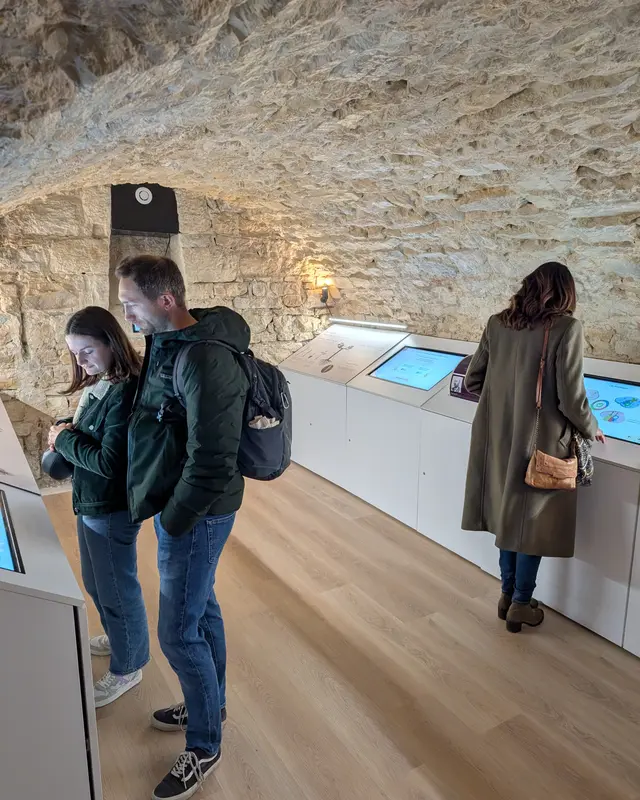 Zwei Besucher erkunden die interaktiven Exponate in den historischen Gewölbekellern des Petit Musée du Vin, Lyon 7. Arr.