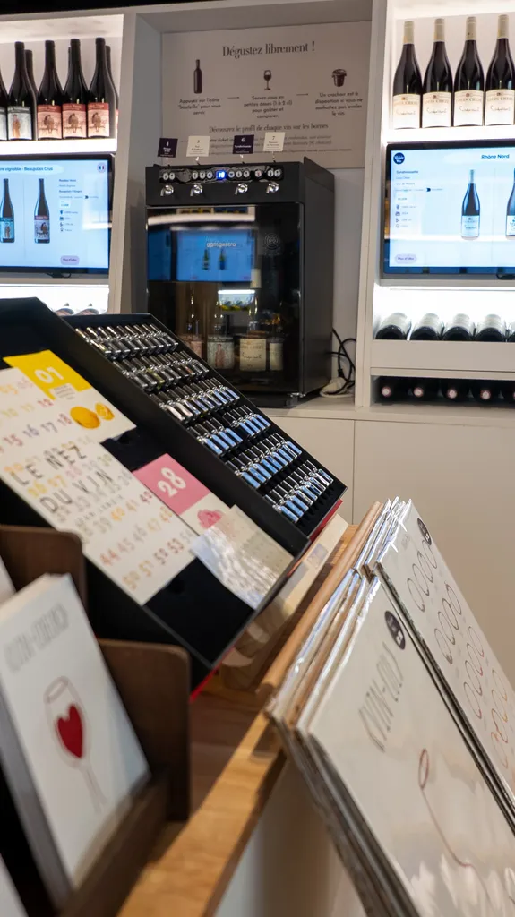 Espace dégustation du Petit Musée du Vin, bouteilles et écrans de sélection des vins