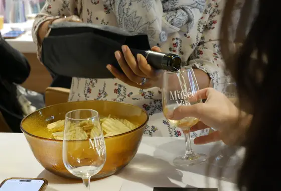 Vin versé dans un verre brandé Le Petit Musée du Vin lors d'une soirée Wine Break