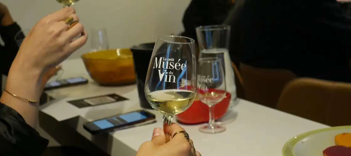 Participantes tenant les verres brandés Le Petit Musée du Vin, ambiance chaleureuse Wine Break